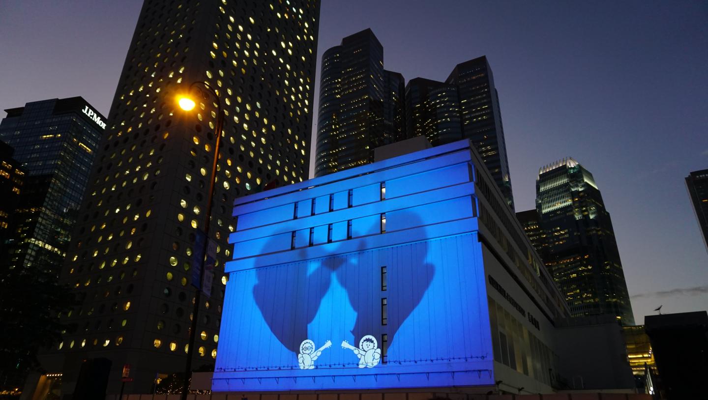 two cartoon characters projected on building in hong kong